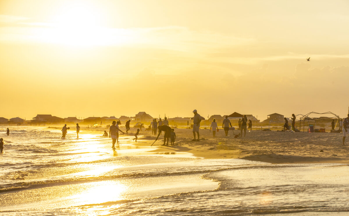People enjoy the beautiful beach in late afternoon at Dauphin I. people enjoy the beautiful beach in sunset at Dauphin Island, USA.